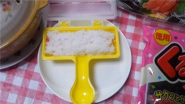 她把白飯放到看起來像玩具的「工具」中,搖了幾下我才發現…發明這個的人真是天才!