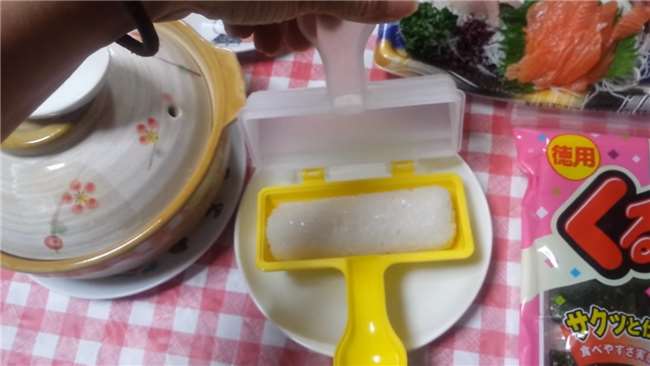 她把白飯放到看起來像玩具的「工具」中,搖了幾下我才發現…發明這個的人真是天才!